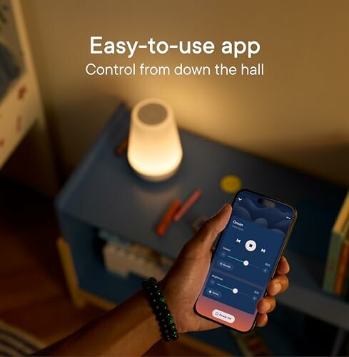 Hand holding smartphone with app controlling light.